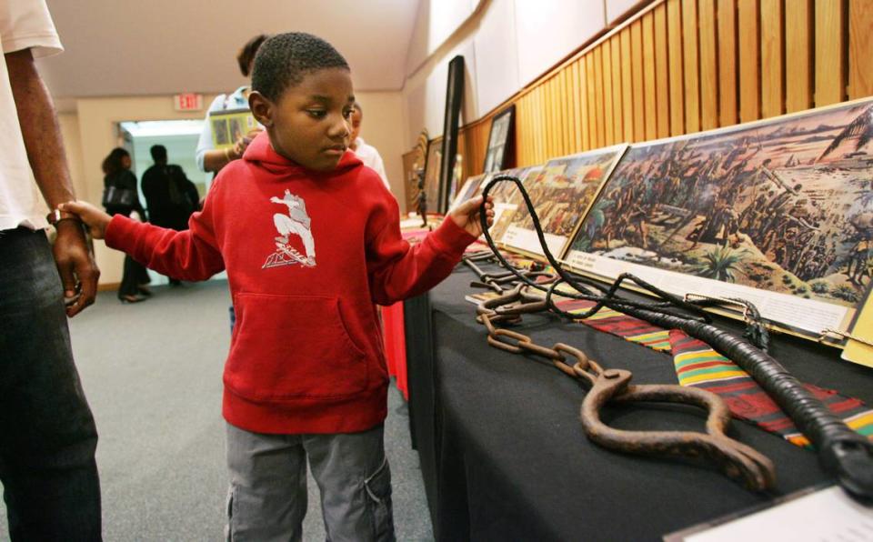 Jayden Burnett, 6, of Pembroke Pines looks at a slave whip at the Sankofa: African American Museum on Wheels exhibit, which was on display at the Southwest Regional Library in Pembroke Pines on February 28, 2007. Shackles from a slave ship are beneath the whip.