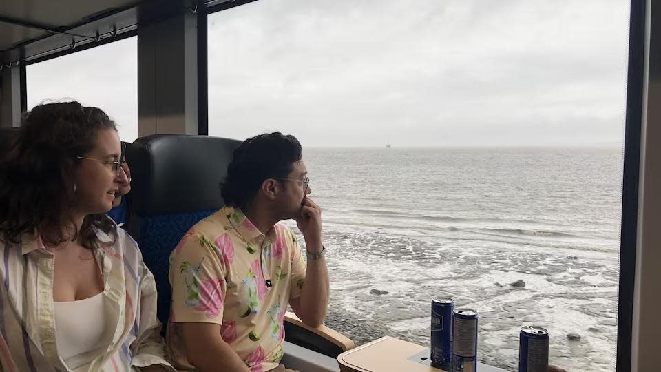 Two passengers take in the view of the river on the two-hour ride on the new hydrogen train.