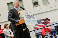 A banner with the pictures of U.S. president Donald Trump and White House Senior adviser Jared Kushner is seen as NYC Mayor Bill de Blasio speaks to demonstrators during a protest against government's tax reforms next to the New York Stock Exchange at the Manhattan borough in New York, U.S., December 2, 2017. REUTERS/Eduardo Munoz