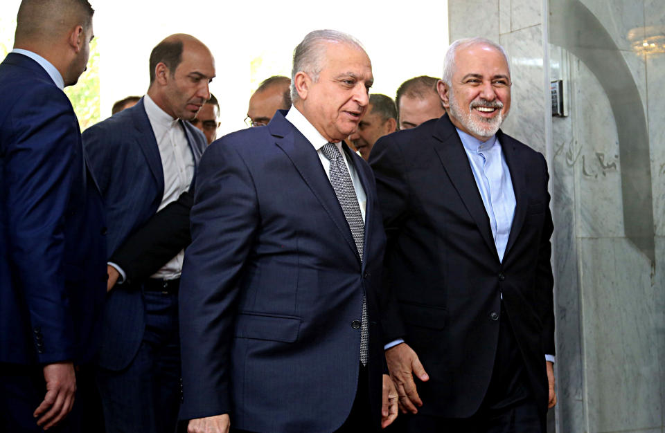 Iraqi Foreign Minister Mohamed Alhahkim, center, walks with his visiting Iranian counterpart Mohammad Javad Zarif, right, at the Ministry of Foreign Affairs Building in Baghdad, Iraq, Sunday, March 10, 2019. (AP Photo/Hadi Mizban)