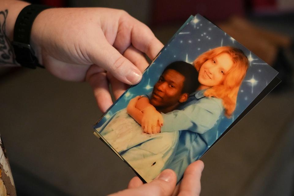 RaeAnne Jones holds photos of herself with Marcus McTear from high school as she discusses her past relationship with McTear while at her home on Friday, Feb. 24, 2023. 