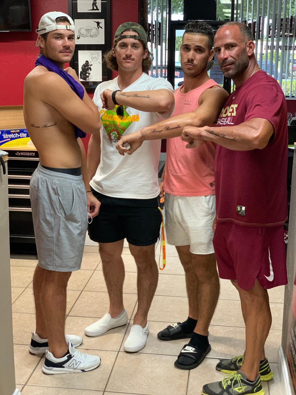 Dylan Crews, Brayden Jobert and Josh Crouch with hitting coach Josh Montero showing off their matching tattoos.