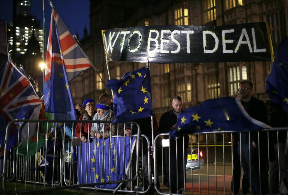 Pro and anti-Brexit supporters gather outside the Houses of Parliament in London, Wednesday, March 13, 2019. Britain's Parliament will vote later Wednesday on whether to rule out leaving the EU on March 29 without a deal. (AP Photo/Tim Ireland)