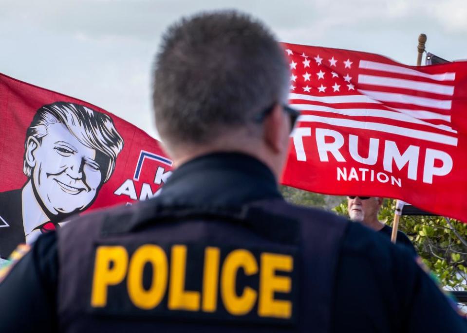 A police officer watches Trump supporters near Mar-a-Lago on Friday.