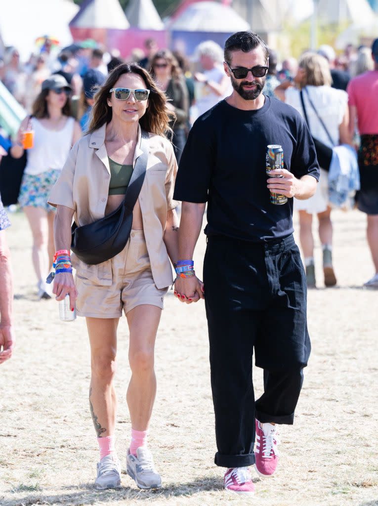 Mel C. (mejor conocida como Sporty Spice) lleva un set más dinámico con camisa y shorts de lino en beige, la cantante apuesta por tenis, calcetas rosas y una bolsa 'crossbody'. 