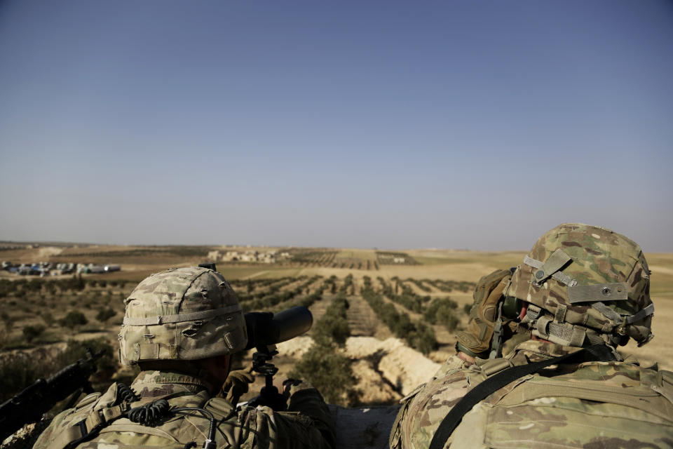 FILE - In this February 7, 2018 file photo, American troops look out toward the border with Turkey from a small outpost near the town of Manbij, northern Syria. The United States’ main ally in Syria on Thursday, Dec. 20, 2018, rejected President Donald Trump’s claim that Islamic State militants have been defeated and warned that the withdrawal of American troops would lead to a resurgence of the extremist group.(AP Photo/Susannah George, File)