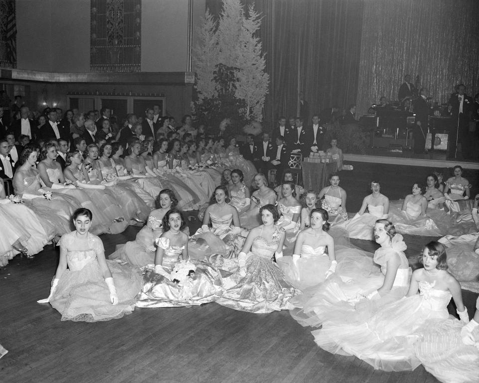 One hundred twenty debutantes dressed in white, or silver, made their debut at the Cotillion and Christmas Ball at the Grand Ballroom of the Hotel Waldorf-Astoria Hotel in New York, Dec. 19, 1949. The ball was for the benefit of the New York Infirmary. (AP Photo/Matty Zimmerman)