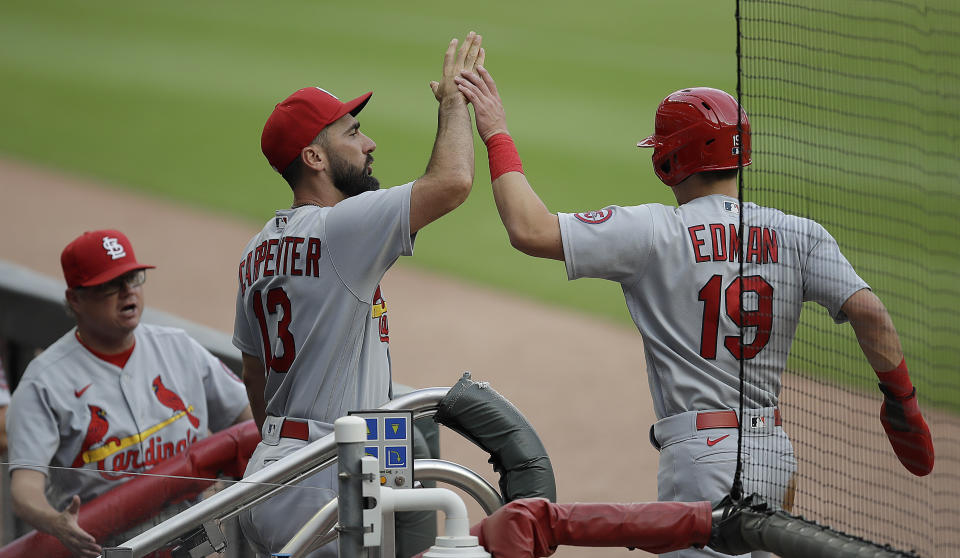 St. Louis Cardinals' Tommy Edman (19) is congratulated by Matt Carpenter (13) after scoring against the Atlanta Braves during the first inning of a baseball game Friday, June 18, 2021, in Atlanta. (AP Photo/Ben Margot)