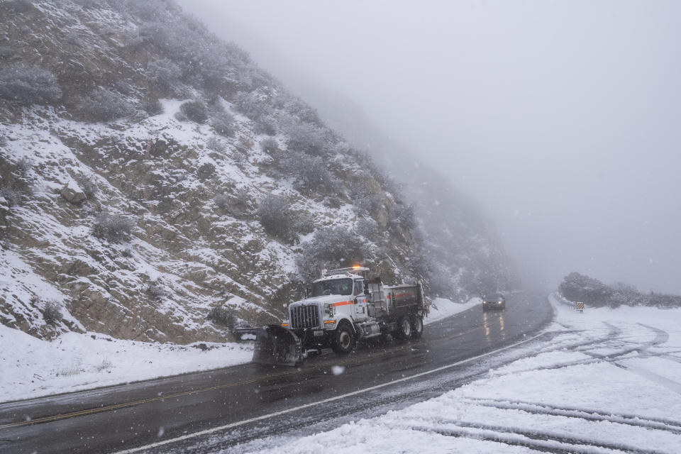 A snow plow truck drives along the Angeles Forest Highway near La Canada Flintridge, Calif., Thursday, Feb. 23, 2023. For the first time since 1989, the National Weather Service issued a blizzard warning for the Southern California mountains. (AP Photo/Jae C. Hong)