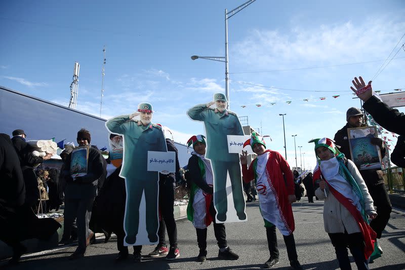 Iranians hold cardboard cutouts of the late Iran's Quds Force top commander Qassem Soleimani, during the commemoration of the 41st anniversary of the Islamic revolution in Tehran