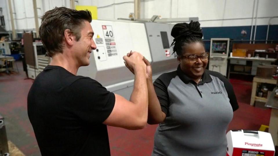 PHOTO: 'World News Tonight' anchor David Muir high fives Igloo Coolers e-commerce manager Anqunette Lewis at the Igloo Coolers factory in Katy, Texas. (ABC News)