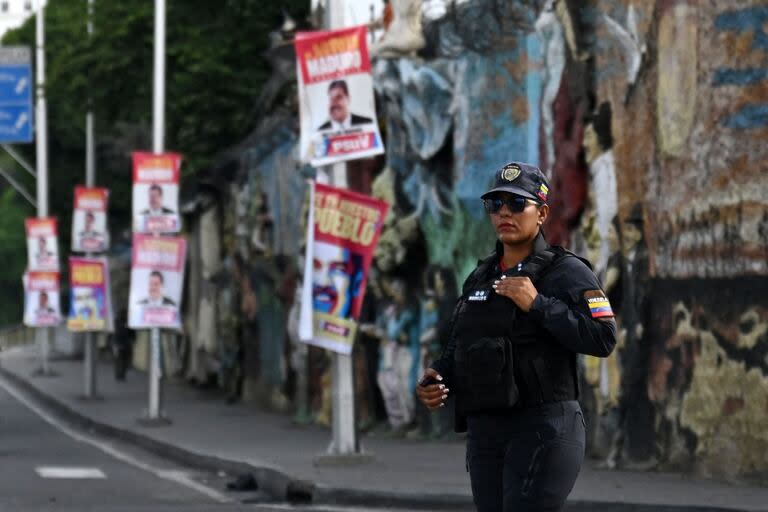 Una policía venezolana, en Caracas, delante de carteles que promocionan la candidatura de Nicolás Maduro. (Raul ARBOLEDA / AFP)