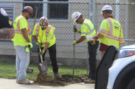 Work crews dig a hole near a street in Ocean City, N.J. on Sept. 12, 2023, at the start of land-based probing along the right-of-way where a power cable for New Jersey's first offshore wind farm is proposed to run. Several protestors were arrested trying to block the work for the project being done by Danish wind energy company Orsted. (AP Photo/Wayne Parry)