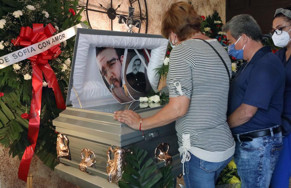 Paramédicos de la Cruz Roja Mexicana y familiares de Juan Andrés García, paramédico de la Cruz Roja y enfermero del IMSS que murió de COVID-19, lloran durante su funeral en Ciudad Juárez, Estado de Chihuahua, Foto de HERIKA MARTINEZ / AFP a través de Getty Images.