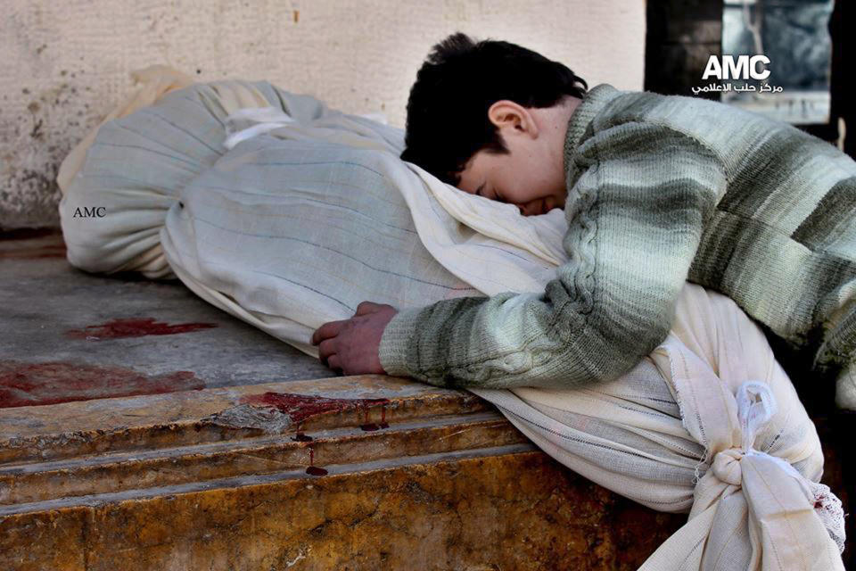 In this citizen journalism image provided by Aleppo Media Center (AMC), an anti-Bashar Assad activist group, which has been authenticated based on its contents and other AP reporting, a Syrian boy weeps over the coffin of his mother who was killed following a Syrian government airstrike in Aleppo, Syria, Friday, Jan. 31, 2014. Activists said the latest Syrian government shelling has killed and wounded several people in a rebel-held area of the northern city of Aleppo. (AP Photo/Aleppo Media Center, AMC)