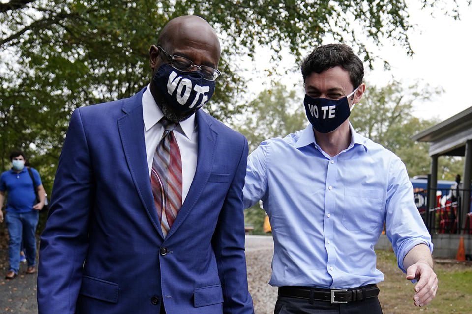 From left, Georgia's Democratic candidates for Senate Raphael Warnock and Jon Ossoff arrive before they speak to a crowd during a 