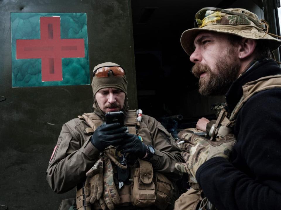 A pair of Ukrainian medical volunteers stand beside the vehicle of the Ukrainian army's mobile evacuation unit near Lysychansk, Eastern Ukraine, on May 10. The city is one of the few in the Luhansk administrative region that has not yet fallen to the Russians. (Yasuyoshi Chiba/AFP/Getty Images - image credit)