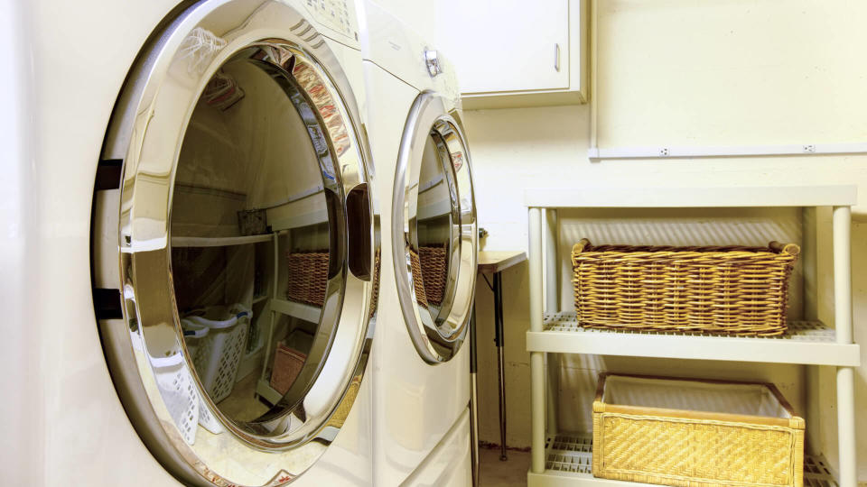 Old style laundry room with modern appliances and wicker baskets.