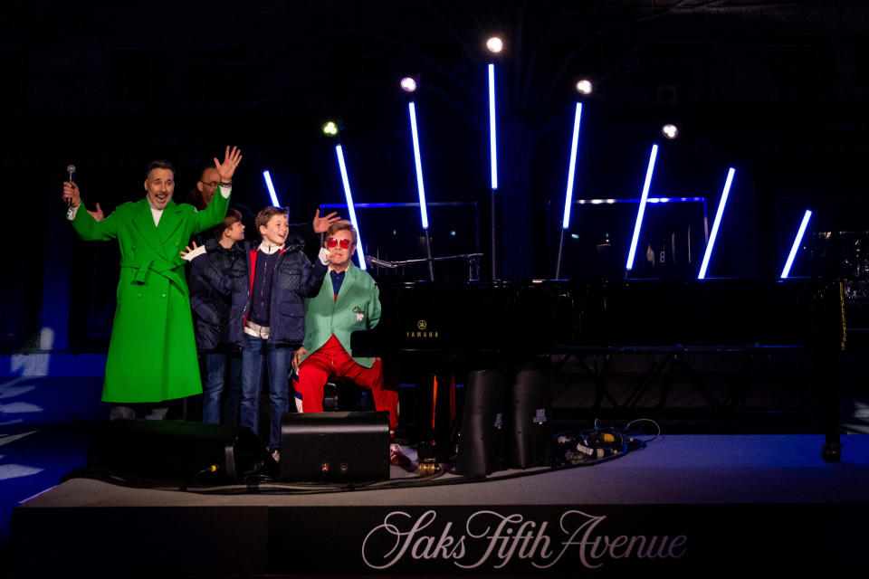 Marc J. Metrick, CEO of Saks Fifth Avenue, along with David Furnish, Elton John, and their sons — Zachary Jackson Levon and Elijah Joseph Daniel — onstage during the opening ceremony for Saks Fifth Avenue's Holiday Windows and Light show in 2022