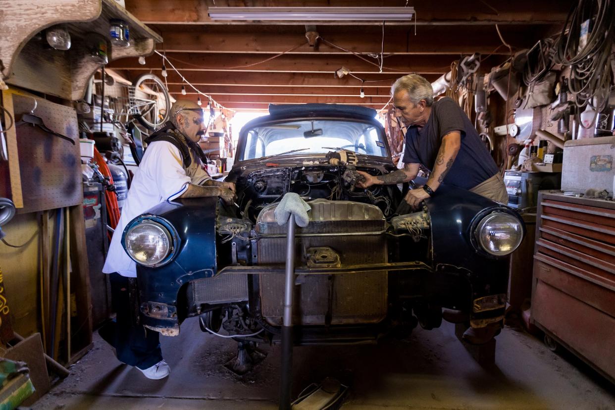 El Paso Chicano rap artist Fabian Primera 'Payaso915' and his dad Larry Primera work on his 1953 Pontiac at his garage in Ysleta, where he grew up and currently lives on Thursday, July 20, 2023.