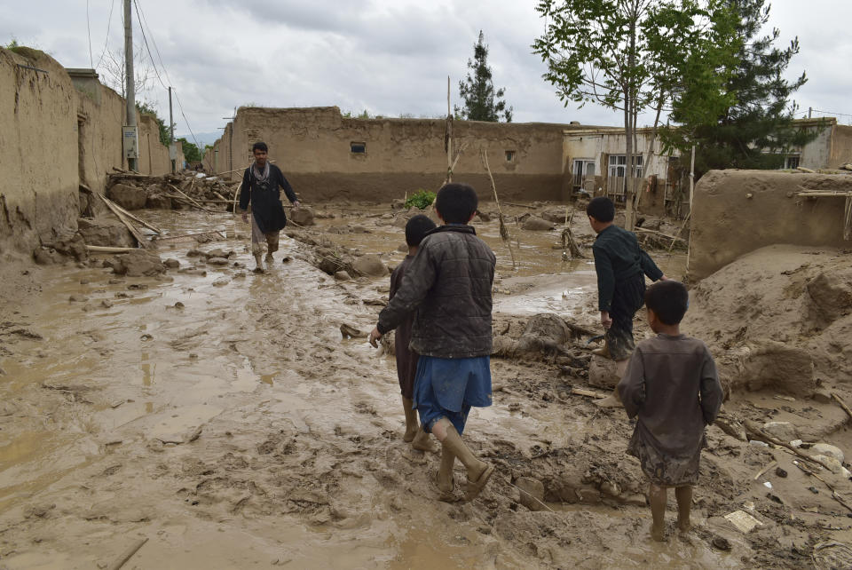 People walk near their damaged homes after heavy flooding in Baghlan province in northern Afghanistan Saturday, May 11, 2024. Flash floods from seasonal rains in Baghlan province in northern Afghanistan killed dozens of people on Friday, a Taliban official said. (AP Photo/Mehrab Ibrahimi)
