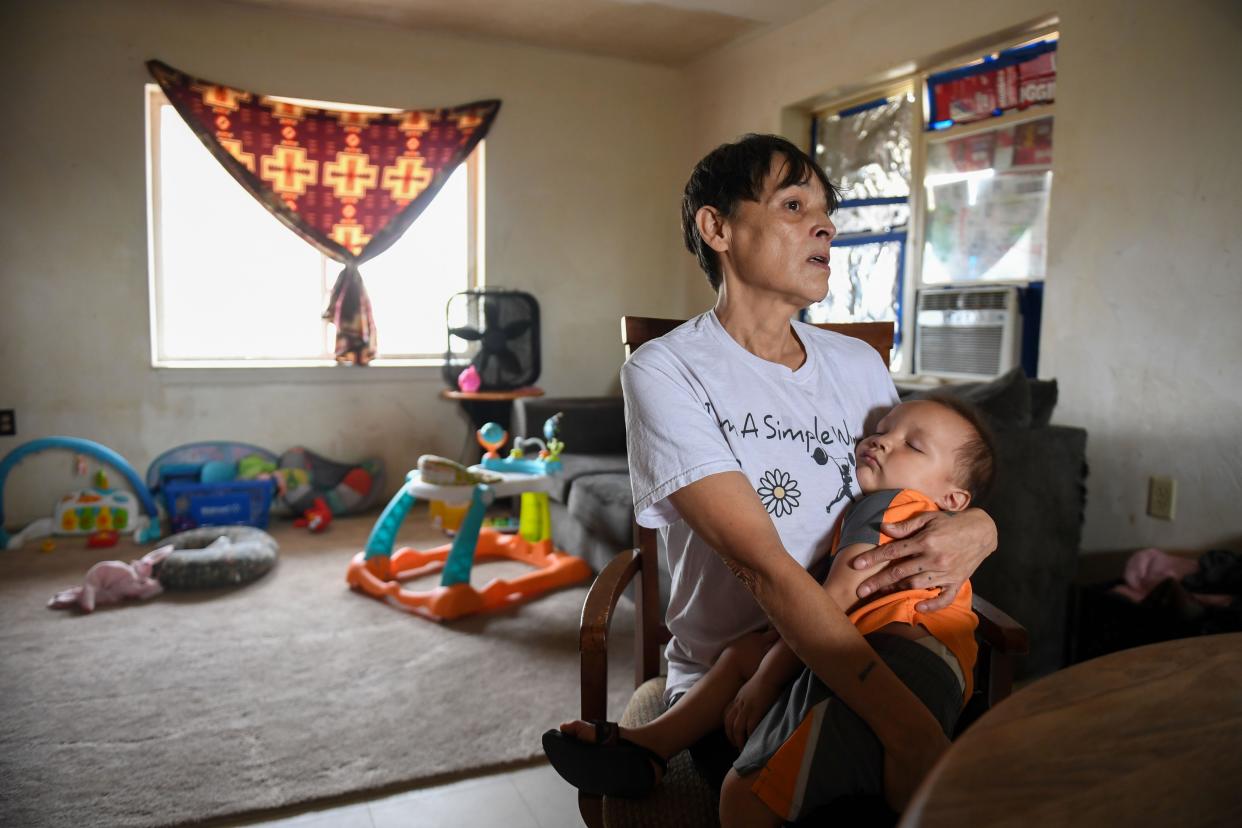 Jewel Bruner tears up while holding her sleeping grandson Gabriel in her Eagle Butte home on Wednesday, Sept. 20, 2023