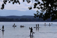 Stand-up paddlers on lake 'Starnberger See' in front of the Alps and Germany's highest mountain 'Zugspitze' (2962 meters) near Seeshaupt, Germany, Sunday, May 10, 2020. (AP Photo/Matthias Schrader)