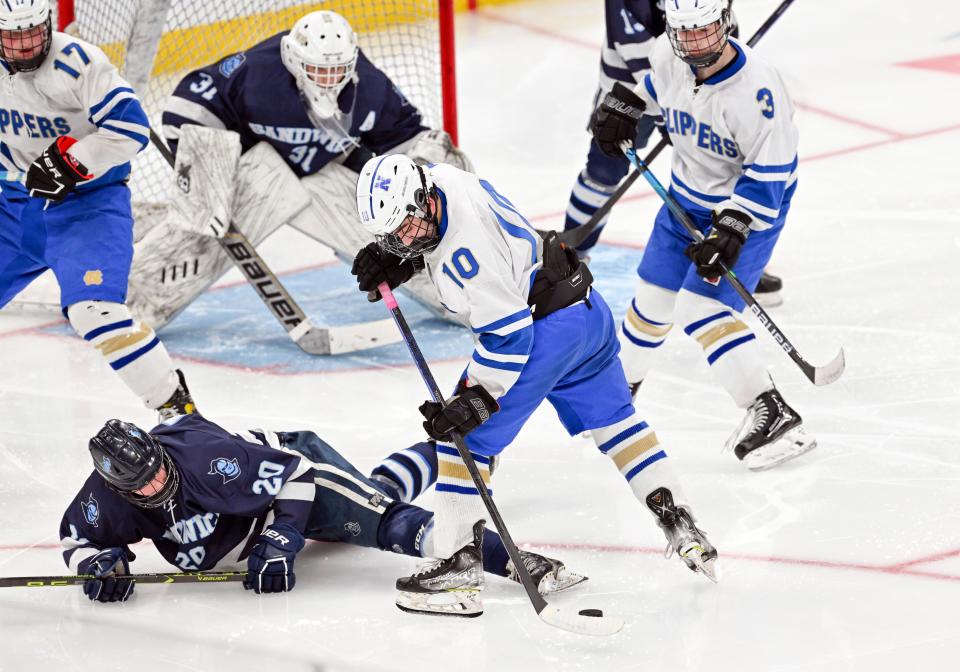 BOSTON 03/19/23  Silas Ohman of Sandwich breaks up the control of the puck by Nolan Petrucelli of Norwell in front of the Sandwich goal in the MIAA Division 4 final hockey