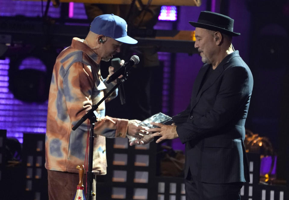 Rene Perez, left, presents the person of the year award to Ruben Blades at the 22nd annual Latin Grammy Awards on Thursday, Nov. 18, 2021, at the MGM Grand Garden Arena in Las Vegas. (AP Photo/Chris Pizzello)