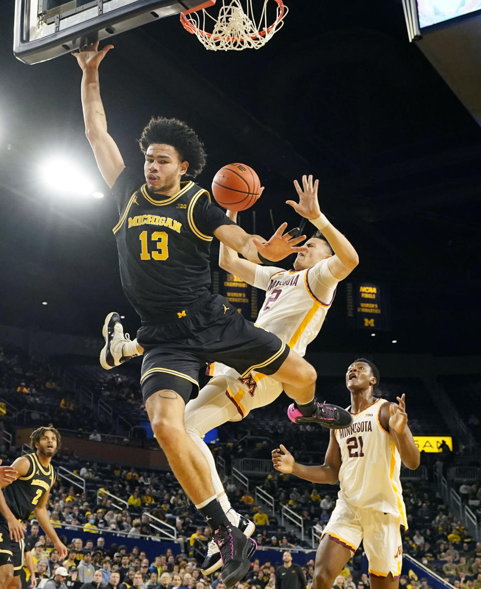 Minnesota guard Mike Mitchell Jr. (2) is fouled by Michigan forward Olivier Nkamhoua (13) during the first half of an NCAA college basketball game, Thursday, Jan. 4, 2024, in Ann Arbor, Mich. (AP Photo/Carlos Osorio)