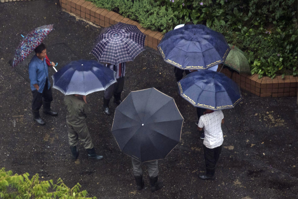 Residents gather under umbrellas as rain falls in Pyongyang, North Korea, Friday, Aug. 24, 2018. Rain from Typhoon Soulik fell in North Korea's capital Pyongyang throughout the morning, but the impact appeared to be mild. Information on what preparations had been taken or if any damage had occurred in the North was not immediately available.(AP Photo/Ng Han Guan)