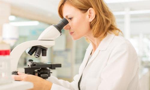 Scientist using microscope