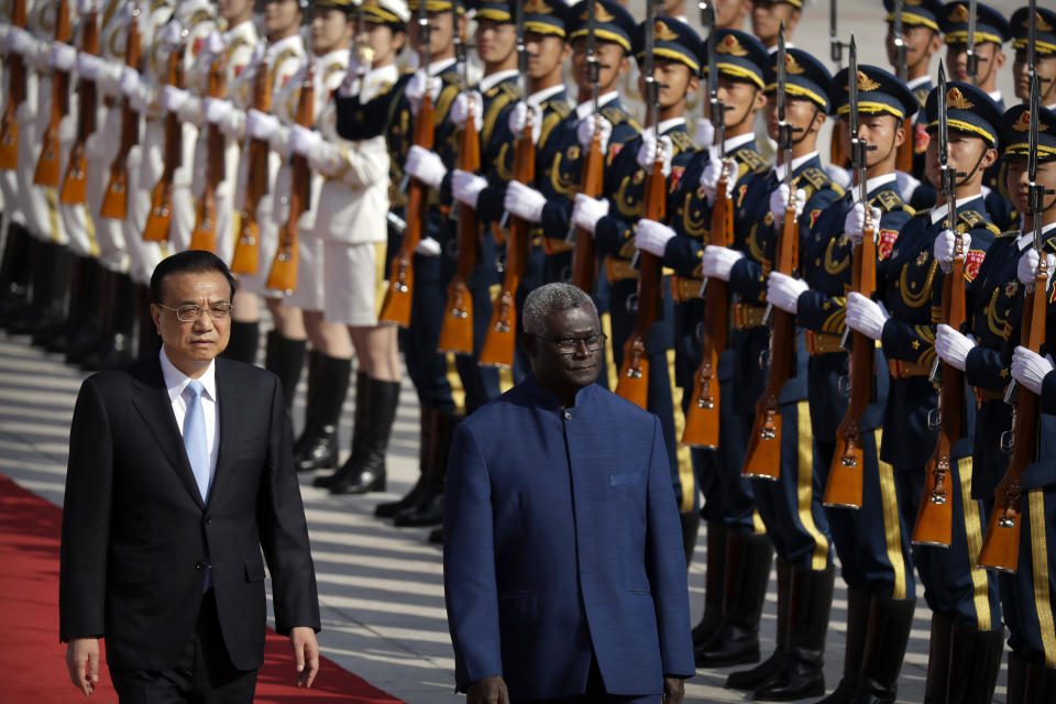 FILE - Chinese Premier Li Keqiang, left, and Solomon Islands Prime Minister Manasseh Sogavare review an honor guard during a welcome ceremony at the Great Hall of the People in Beijing, on Oct. 9, 2019. When China signed a security pact with the Solomon Islands in April, 2022, it raised concerns from the U.S. and its allies that Beijing may be seeking a military outpost in the South Pacific, an area of traditional American naval dominance. (AP Photo/Mark Schiefelbein, File)