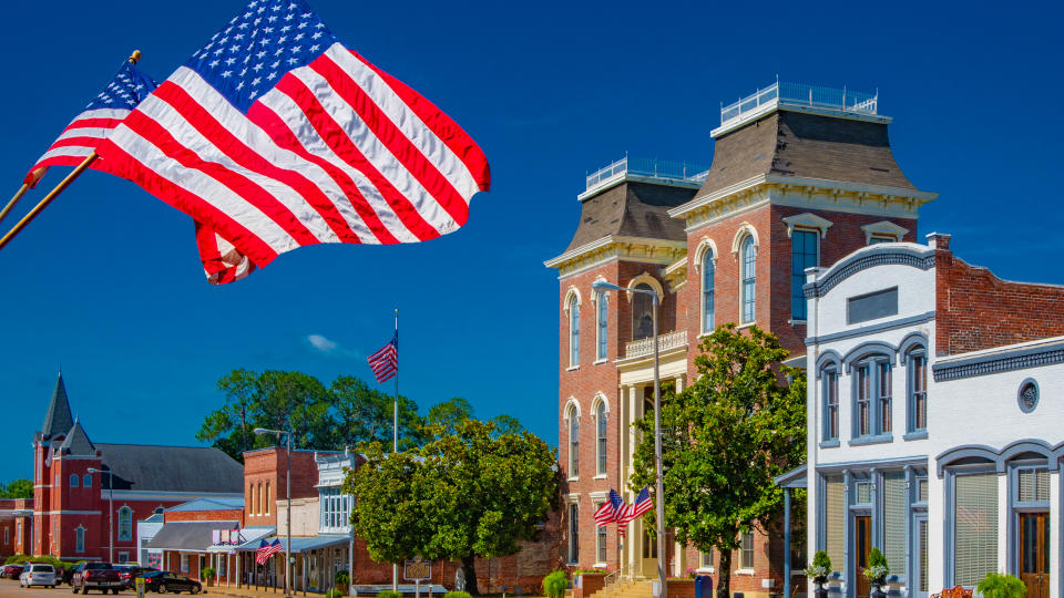 American Flags flying in a small town square.