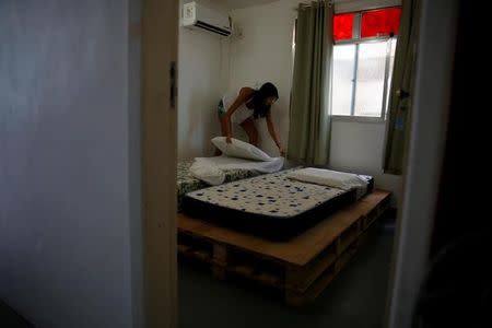 Milene prepares a room at Tiki hostel in Cantagalo favela, in Rio de Janeiro, Brazil, May 1, 2016. REUTERS/Pilar Olivares