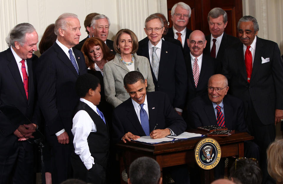 Speaker of the House Nancy Pelosi stands behind President Barack Obama as he signs the Affordable Health Care for America Act during a ceremony with fellow Democrats in the East Room of the White House on March 23, 2010.<span class="copyright">Win McNamee—Getty Images</span>