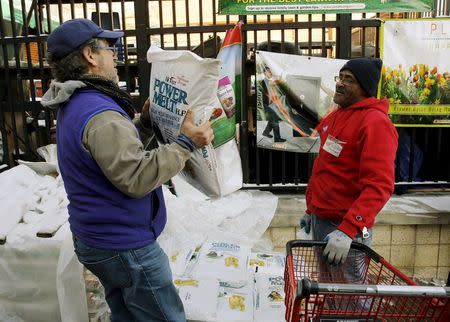 Employee Michael Torney (R) watches a customer carry out a bag of ice melt at Strosniders Hardware store in Silver Spring, Maryland January 21, 2016. REUTERS/Gary Cameron