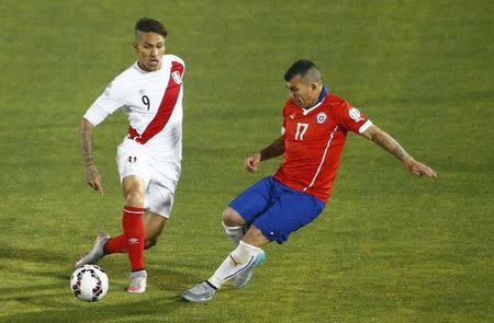 Peru's Paolo Guerrero (L) challenges Chile's Gary Medel during their Copa America 2015 semi-final soccer match at the National Stadium in Santiago, Chile, June 29, 2015. REUTERS/Ricardo Moraes