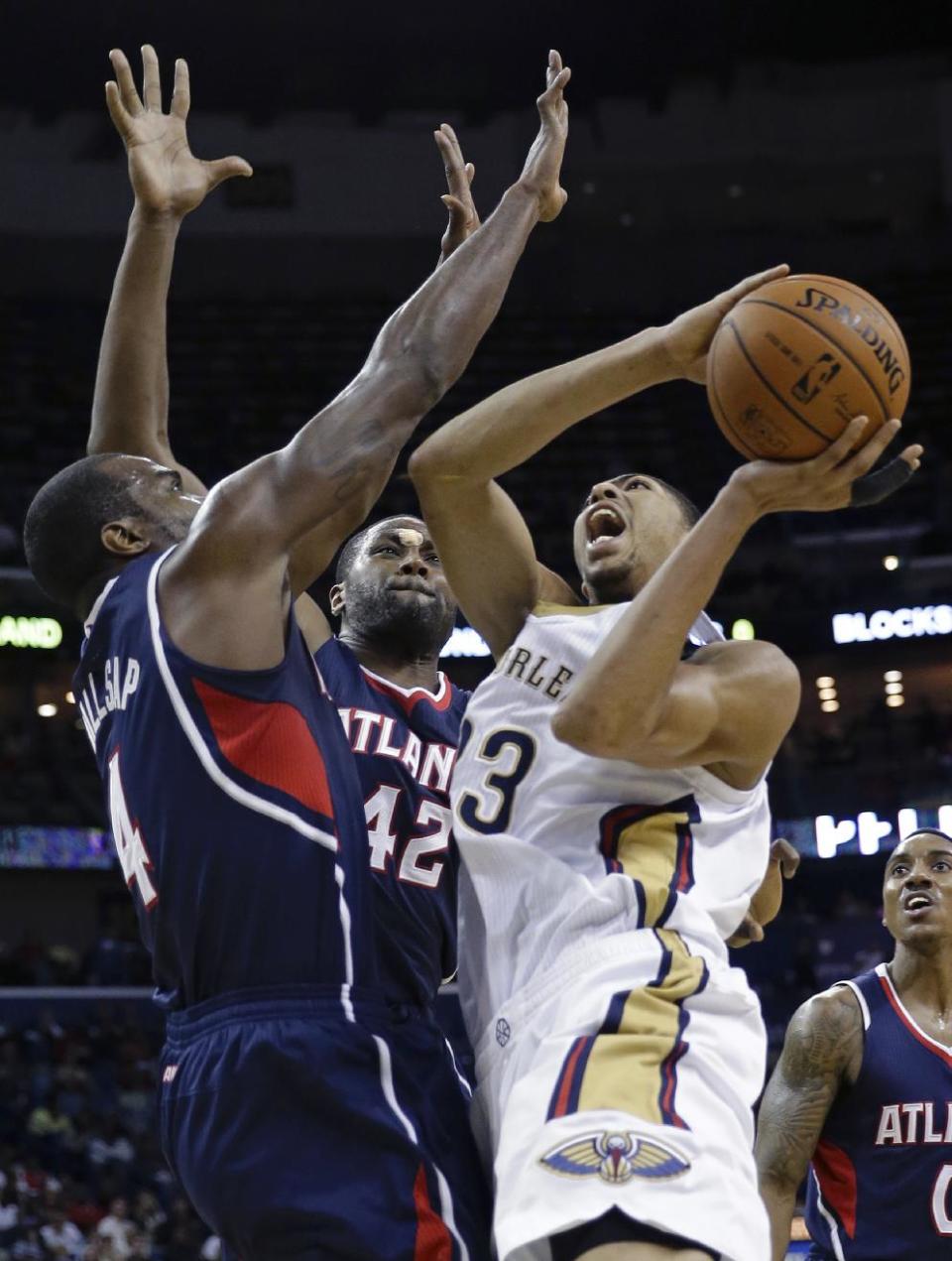 New Orleans Pelicans power forward Anthony Davis (23) shoots against Atlanta Hawks power forward Paul Millsap (4) and power forward Elton Brand (42) in the second half of an NBA basketball game in New Orleans, Wednesday, Feb. 5, 2014. The Pelicans won 105-100. (AP Photo/Gerald Herbert)