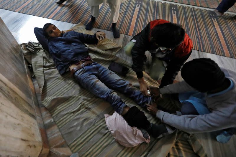 An injured man is treated inside a mosque after he was wounded in a protest against a new citizenship law, in New Delhi