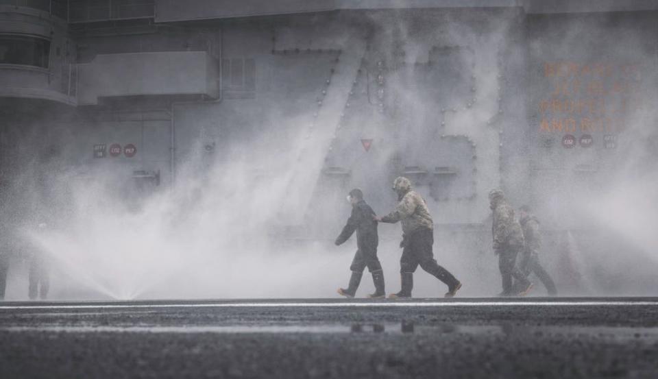 Sailors participate in saltwater washdown on Nimitz-class aircraft carrier USS George Washington