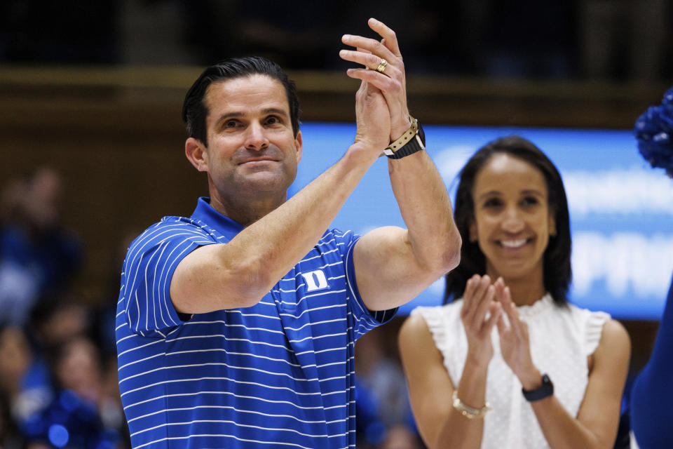 Newly-hired Duke head football coach Manny Diaz, left, is introduced to the home crowd with Athletic Director Nina King, right, during an NCAA college basketball game against Charlotte in Durham, N.C., Saturday, Dec. 9, 2023. (AP Photo/Ben McKeown)