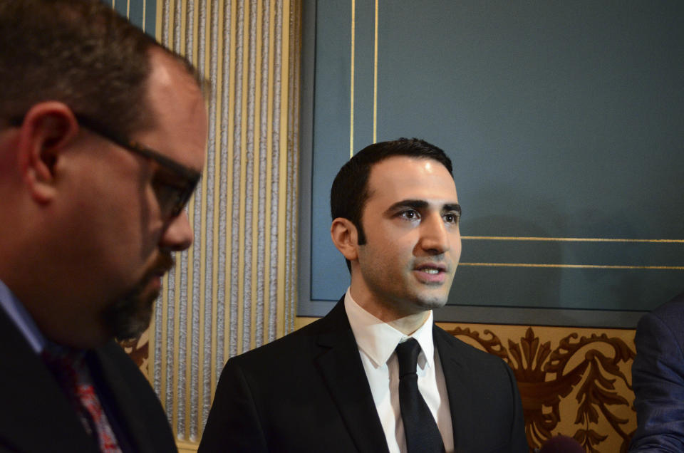 FILE - In this May 26, 2016, file photo, Amir Hekmati, right, speaks with the media in the Michigan Senate Chamber in Lansing, Mich. A former U.S. Marine freed from Iranian custody five years ago is in court with the American government over whether he can collect a multimillion-dollar payment from a special fund for victims of international terrorism. Newly filed court documents show that the FBI opened an investigation into Hekmati, on suspicions that he went to Iran to sell classified information to the regime. He vigorously disputes those allegations.(AP Photo/Michael Gerstein, File)