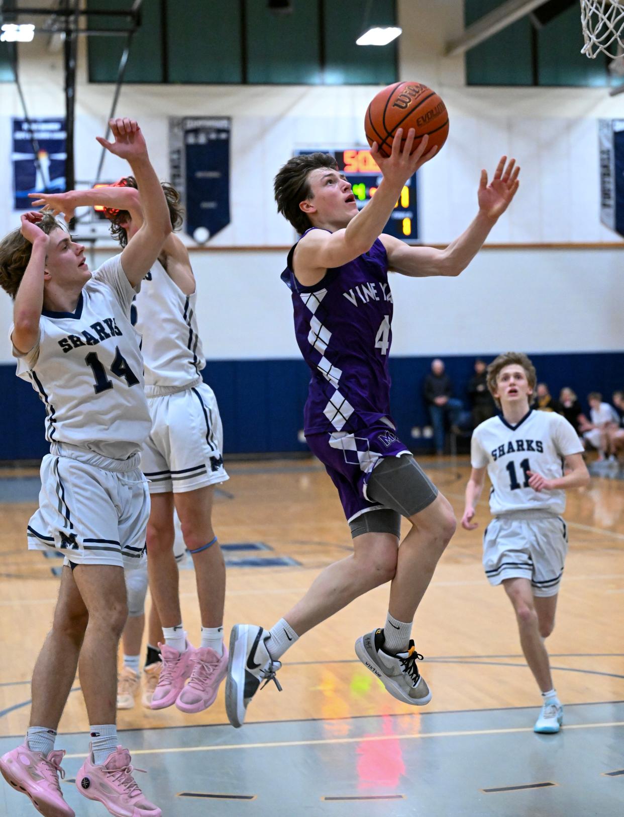 HARWICH  01/26/24 Nate Story of Martha's Vineyard slides across the lane past Jarrett Morneau of Monomoy boys basketball
Ron Schloerb/Cape Cod Times