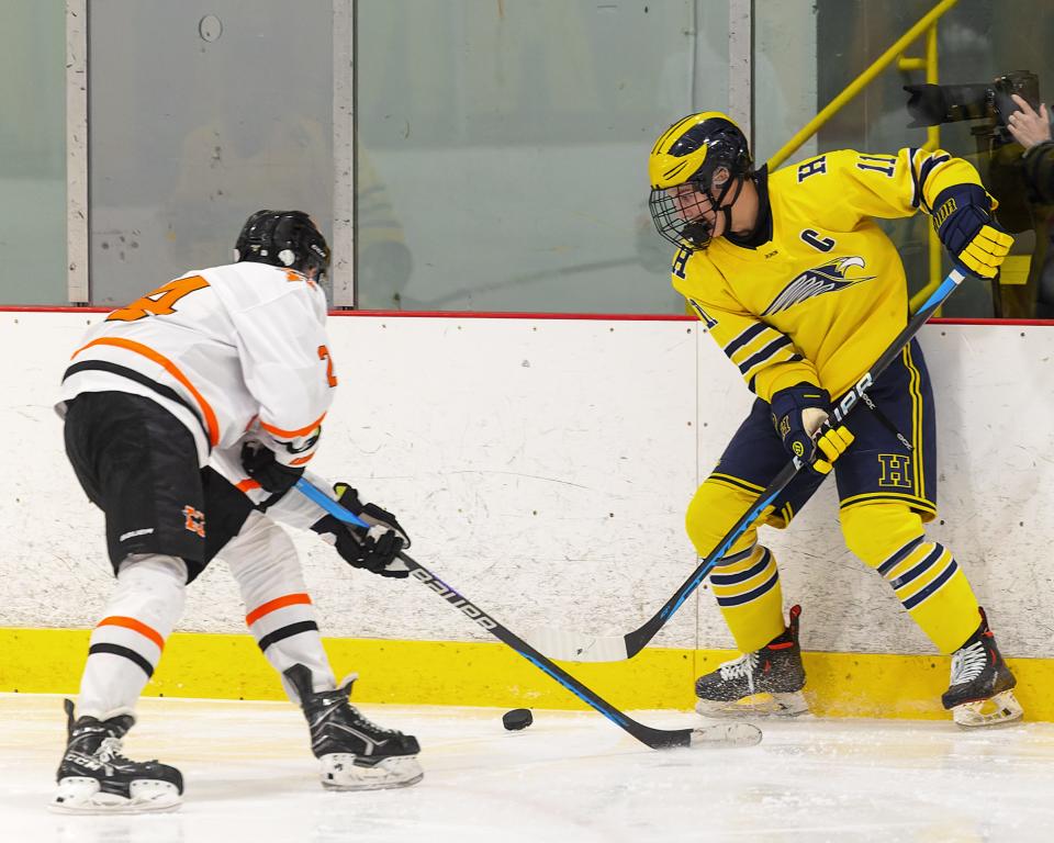 Hartland's Ben Pouliot (11) battles for the puck along the boards with Northville's Nate Ewasek during the Eagles' 6-1 victory on Wednesday, Jan. 4, 2023 at Hartland Sports Center.
