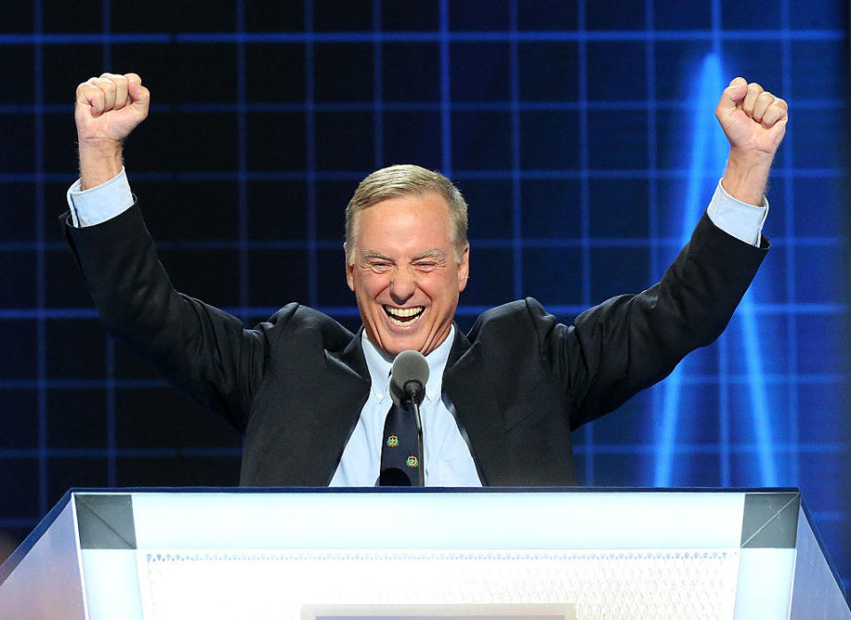 Howard Dean lifting his arms in excitement behind a podium