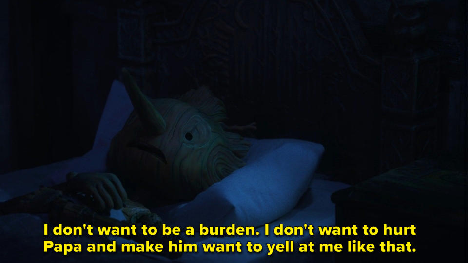 a wooden boy talks to himself while lying in his bed