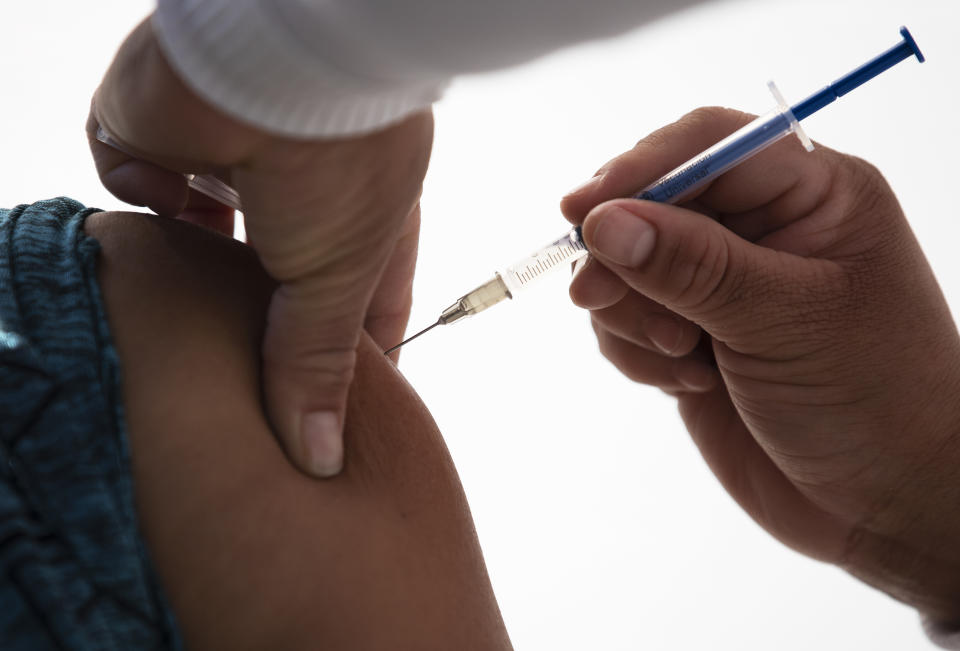 FILE - In this Dec. 30, 2020 file photo, a healthcare worker receives a dose of the Pfizer-BioNTech COVID-19 vaccine at the N-1 military base in Mexico City, Wednesday, Dec. 30, 2020. Mexico will start vaccinating teachers and other school personnel in Campeche, one of the country's 32 states this weekend with an eye toward resuming in-person classes there as early as late next month, President Andrés Manuel López Obrador said Friday, Jan. 22, 2021. (AP Photo/Marco Ugarte, File)