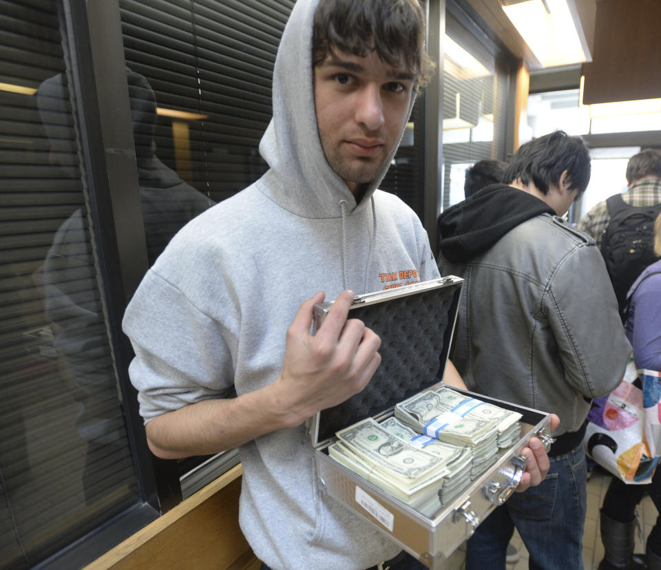 University of Utah student Luke Mughal holds a briefcase full of one-dollar bills as he waits in a long line to pay his tuition at the Student Services Building on the University of Utah campus in Salt Lake City, Utah Tuesday, Jan. 21, 2014. Mughal is paying his tuition in one-dollar bills to protest the high cost of tuition. (AP Photo/The Salt Lake Tribune, Steve Griffin)