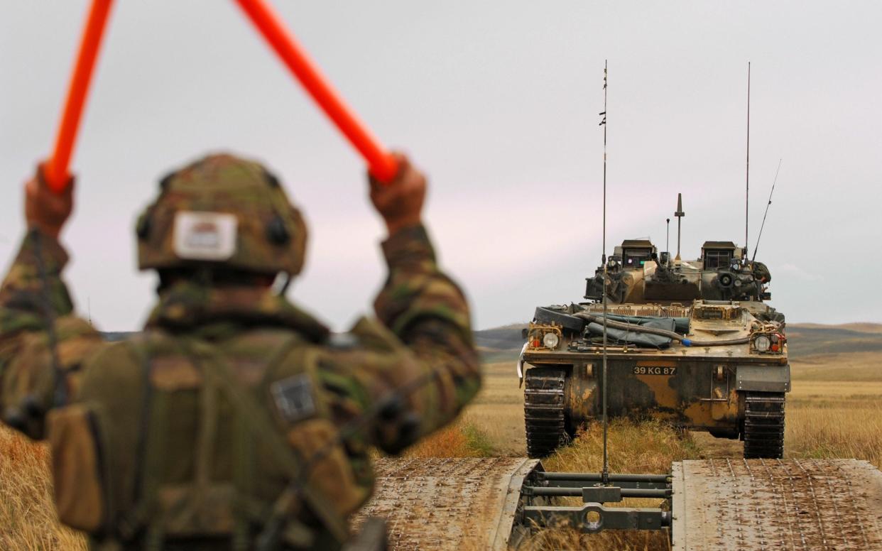 A member of the Royal Engineers guides a tank at the British Army Training Unit Suffield in Canada - Cpl Russ Nolan RLC/Crown Copyright